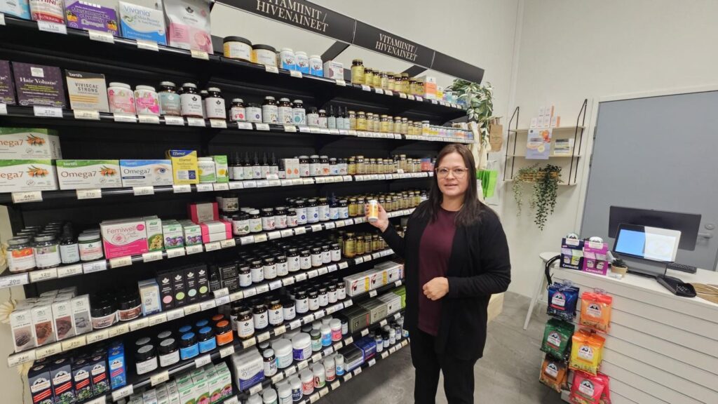 Terveyskaupan kauppias vitamiinihyllyn äärellä