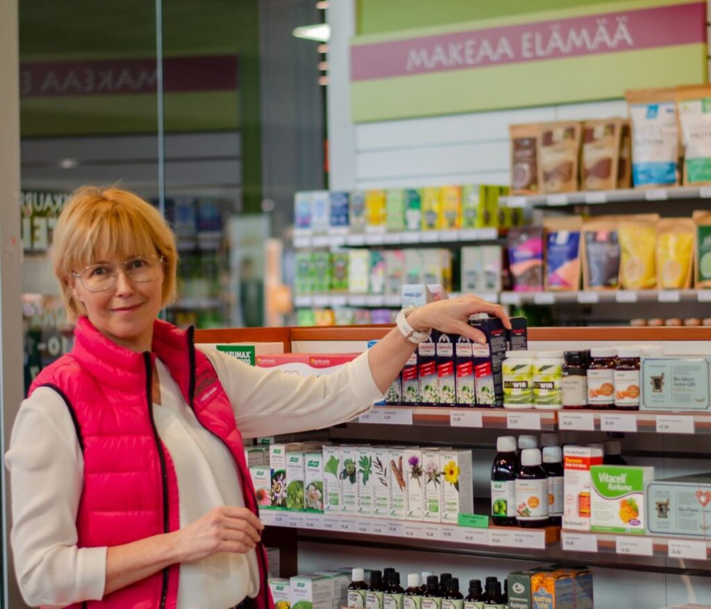 Terveyskaupan kauppias rohdosvalmistehyllyllä